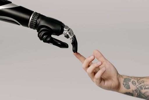 Photograph capturing a moment of connection and collaboration between a robot hand and a human hand. The image shows a robot hand, designed with precision and metallic elements, gently meeting a human hand, emphasizing the harmony between humans and technology. This symbolic interaction signifies cooperation, teamwork, and the potential for humans and robots to work together in various fields, such as robotics, automation, and advanced manufacturing.